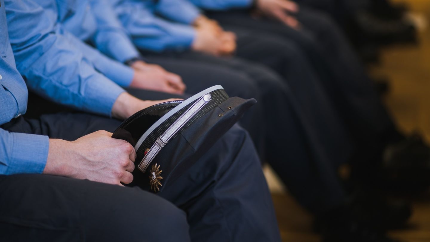 2020: Forschungsprojekt der HWR Berlin zur Imagekampagne der Berliner Polizei Polizistinnen und Polizisten in Uniform sitzen in einer Reihe auf Stühlen, einer hält seine Mütze auf dem Knie. Foto: Oana Popa-Costea