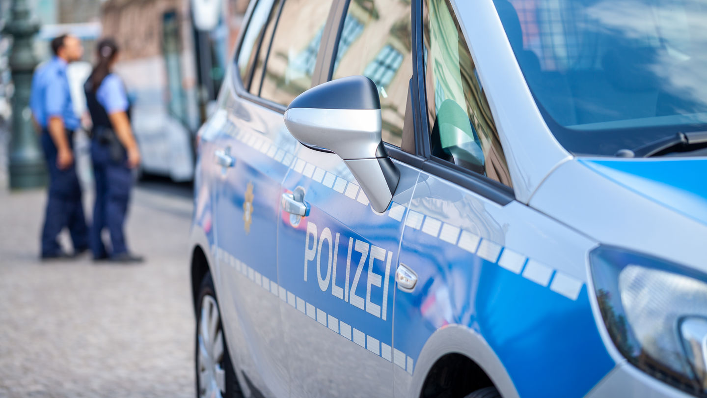 Forschungsprojekt Police Accountability an der HWR Berlin. Foto: © huettenhoelscher/iStock/Getty Images Plus Berliner Polizeiauto auf der Straße. Im Hintergrund sind eine Polizistin und ein Polizist in Uniform zu sehen. Foto: © huettenhoelscher/iStock/Getty Images Plus
