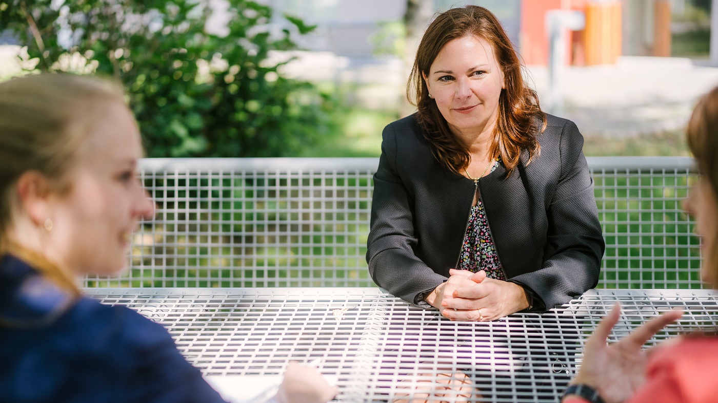 Prof. Dr. Sabrina Schönrock, Verfassungsrichterin des Landes Berlin, sitzt im Freien am Tisch und wird von zwei Mitarbeiterinnen interviewt. Foto: Alexander Rentsch